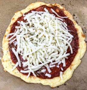 Mozzarella cheese added to a keto pizza crust
