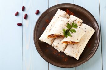 Burritos on a brown plate on a white table